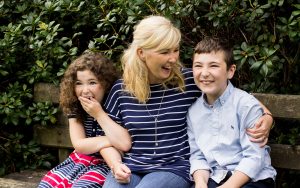 Mel Hudson Family Photography Belfast, Mum, son & daughter sitting on a park bench smiling and laughing