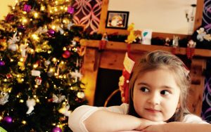Mel Hudson Family Photography Belfast, little girl sitting beside a Christmas Tree