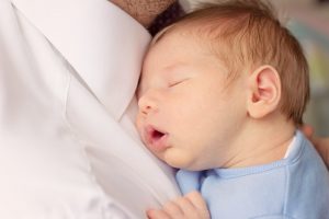 Newborn boy being cradled by daddy in a Newborn photoshoot at home Co Antrim